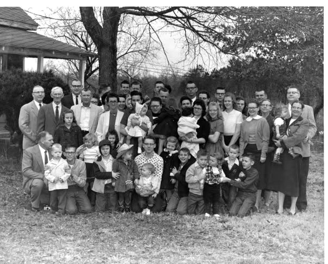 The extended Holland family photographed together in a yard in West Tennessee around 1960, roughly forty adults and children